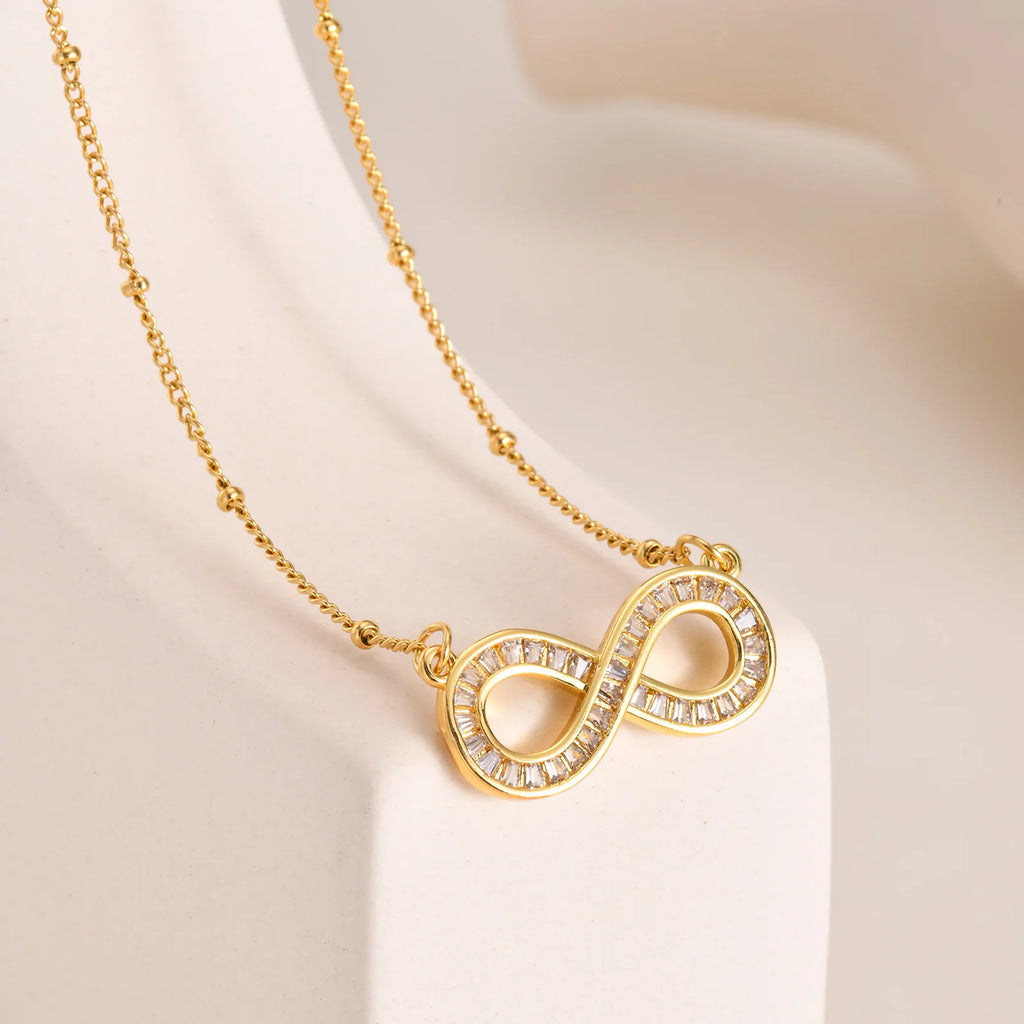 Collar con colgante de infinito de acero inoxidable chapado en oro de 14 quilates con cadena de cuentas y circonitas .