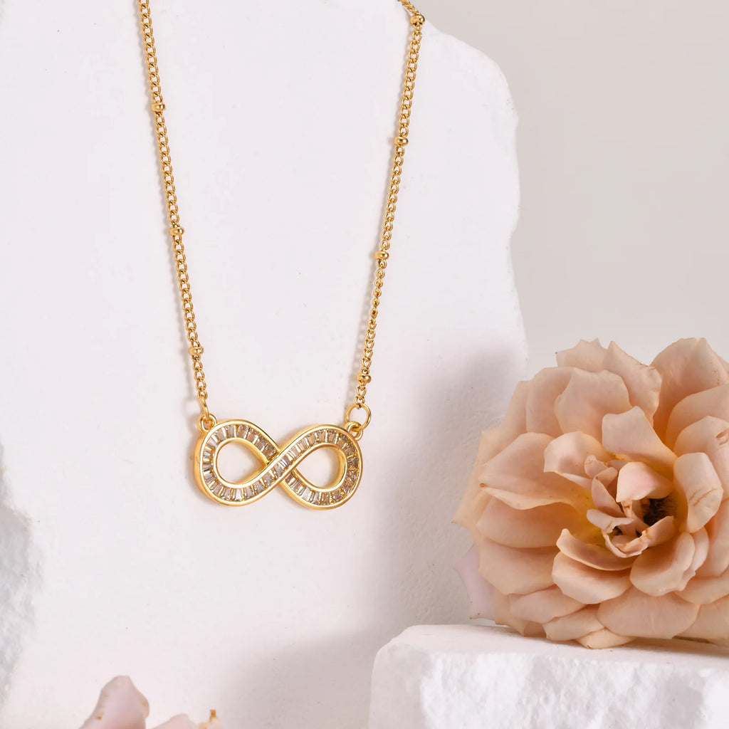 Collar con colgante de infinito de acero inoxidable chapado en oro de 14 quilates con cadena de cuentas y circonitas .