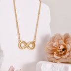 Collar con colgante de infinito de acero inoxidable chapado en oro de 14 quilates con cadena de cuentas y circonitas .